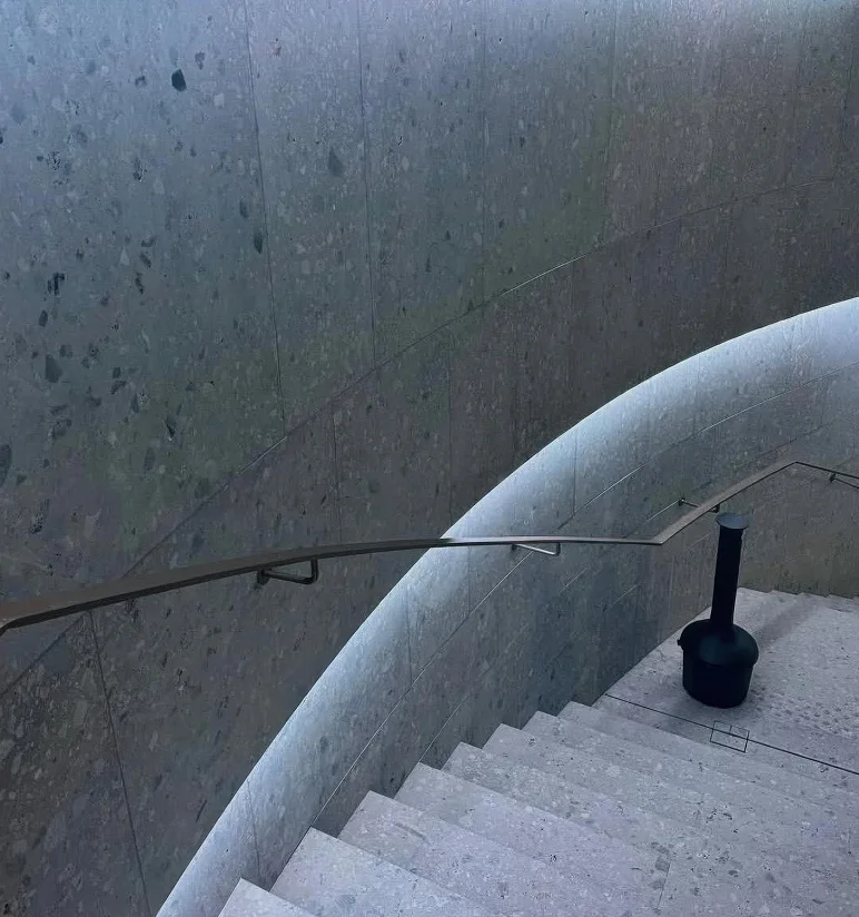 Scala curva con rivestimento a parete in Agglotech SB130 Aggloceppo levigato e sabbiato nel progetto di rinnovamento di Piazza Dante nel centro storico di Bergamo - Trapattoni Marmi