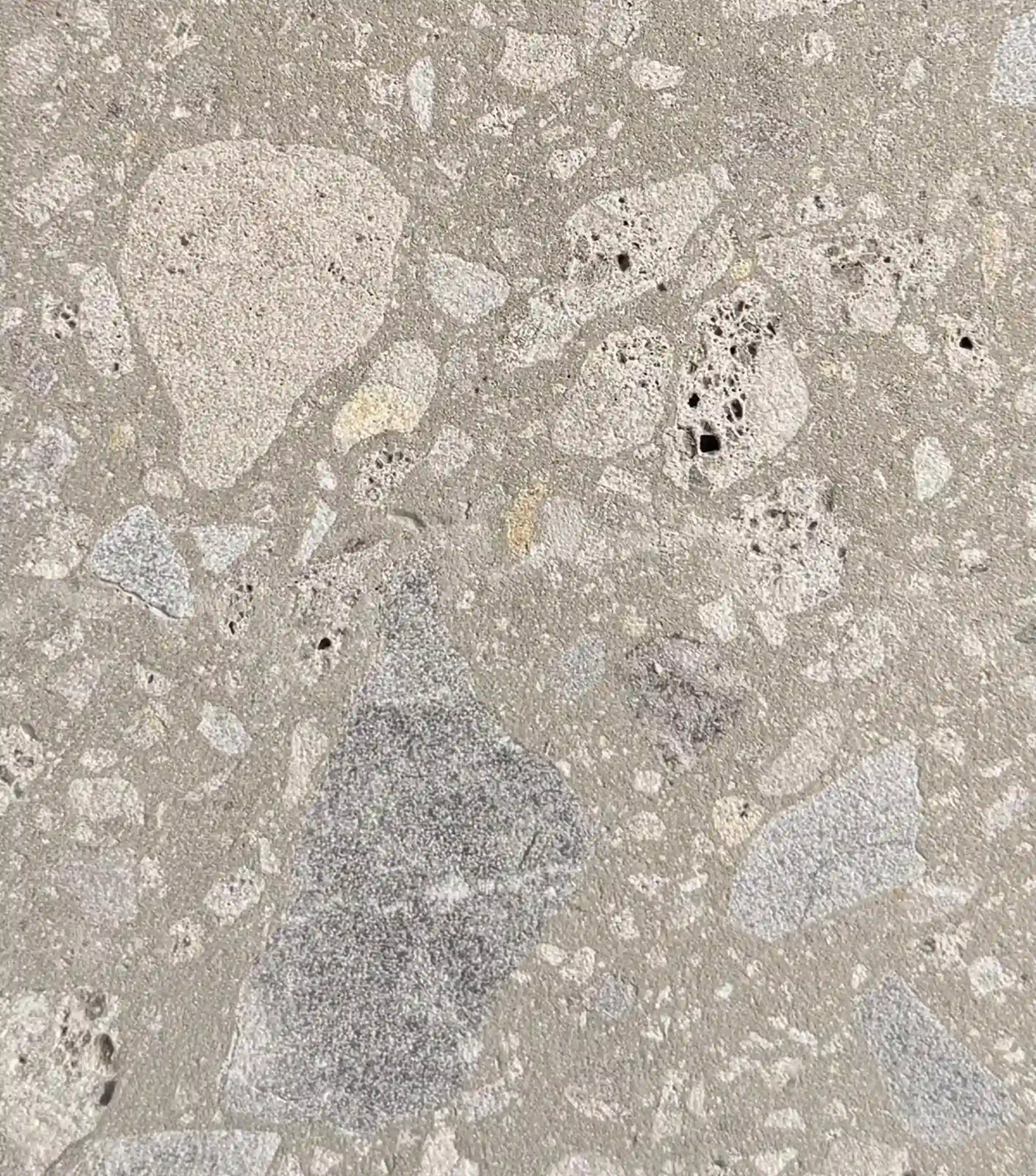 Campione di Agglotech SB130 Aggloceppo con finitura sabbiata – Terrazzo alla Veneziana grigio con inserti di grandi dimensioni in toni avorio e grigio scuro con cavità naturali, utilizzato per pavimentazione e rivestimenti curvilinei nel rinnovamento di Piazza Dante a Bergamo – Trapattoni Marmi